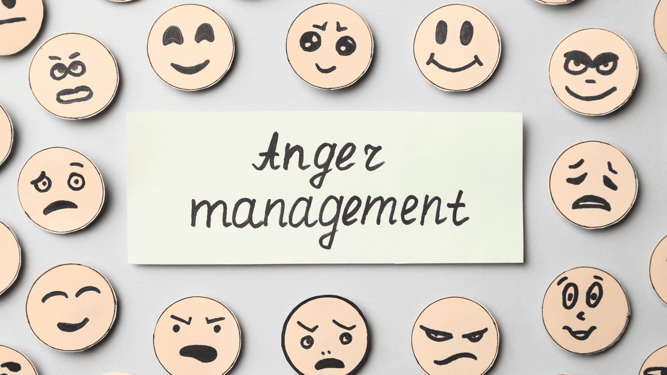The words Anger Management are written in black cursive on an off-white rectangular area surrounded by different facial expressions on wooden circles on a gray background. Mental Health. Coping Skills. Diversion. Warning Signs. Triggers. Anger Log. Time outs